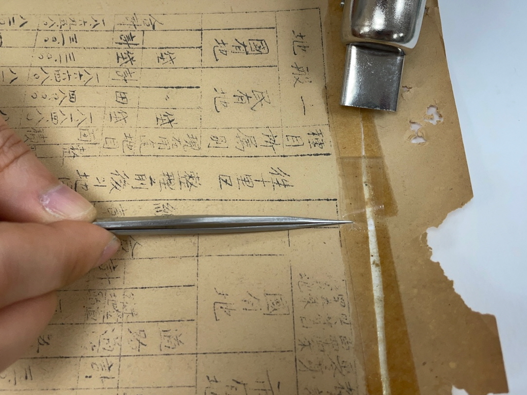 복원 도구를 이용하여 문서에 붙은 테이프에 열을 가하는 모습.